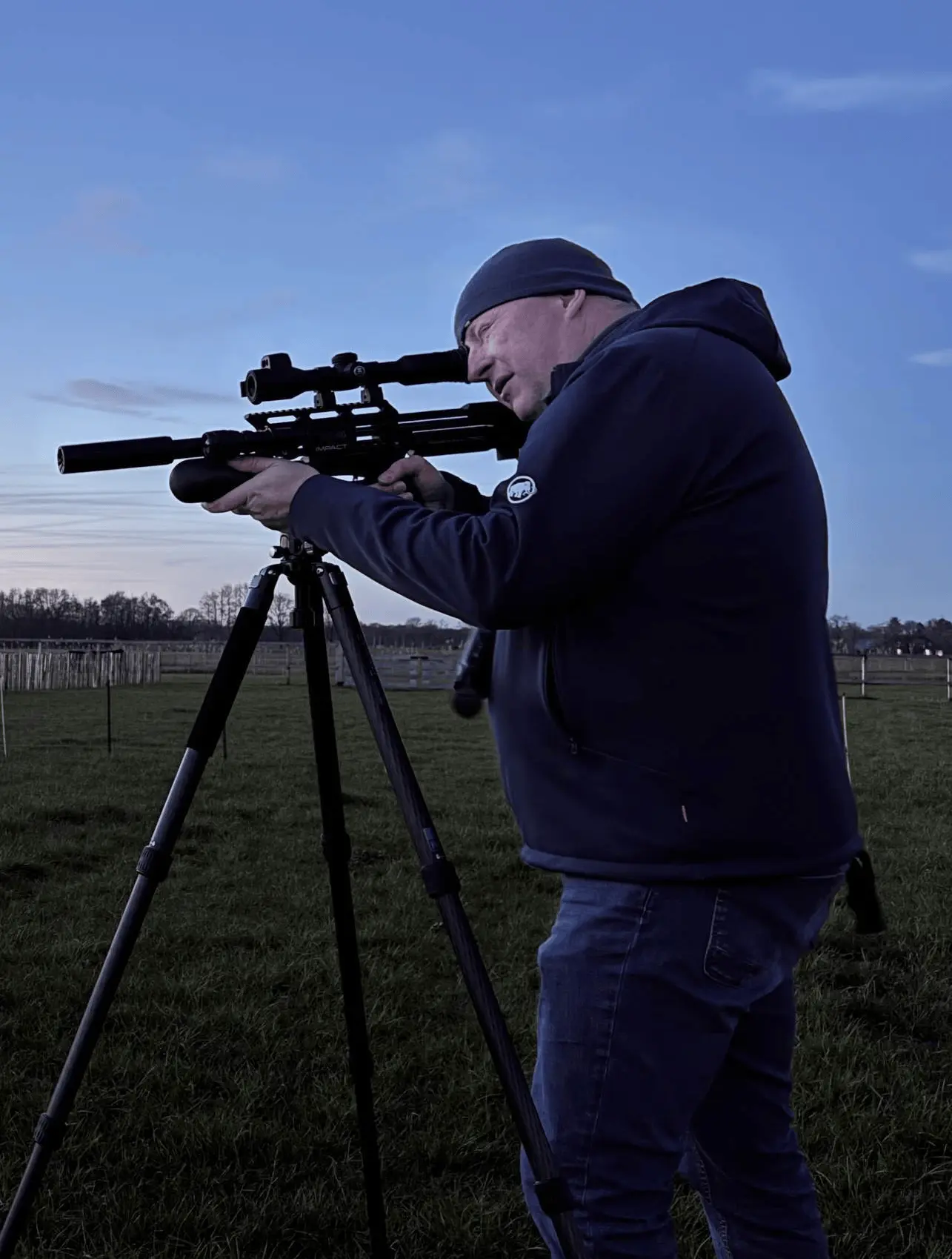 Person aiming scoped rifle